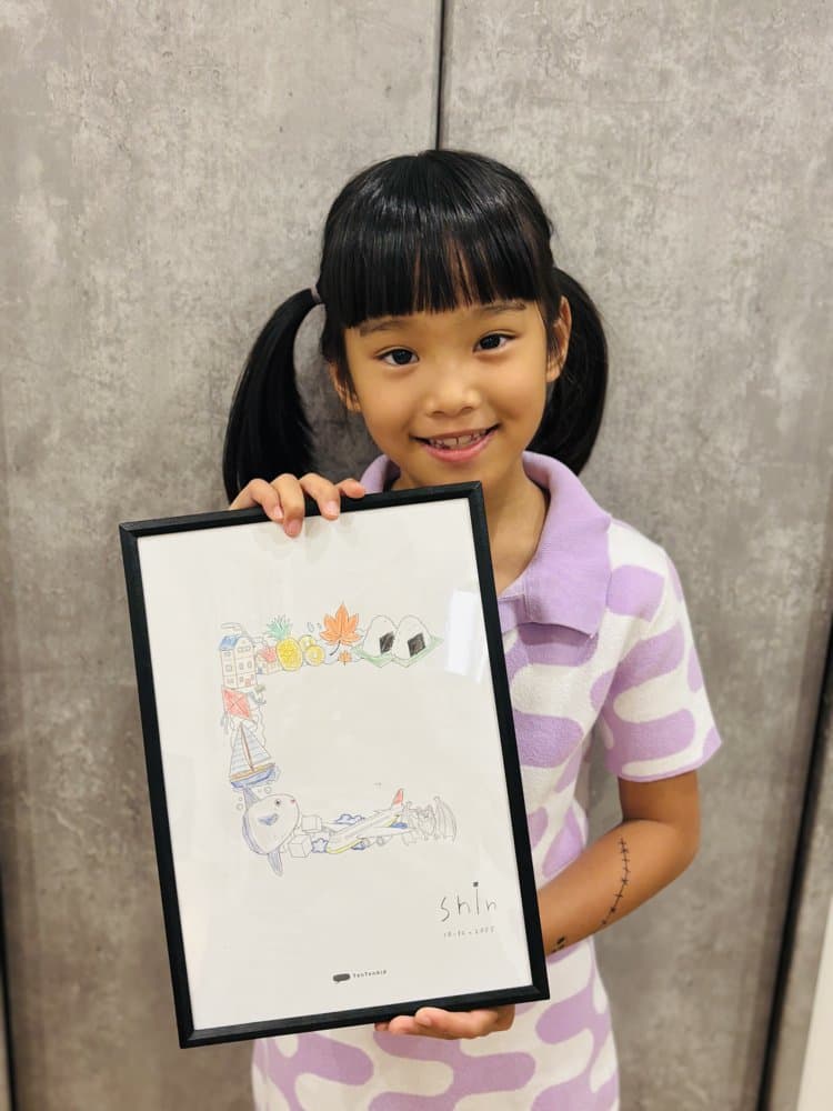 Shin小女孩拿著藝術注音裱框作品